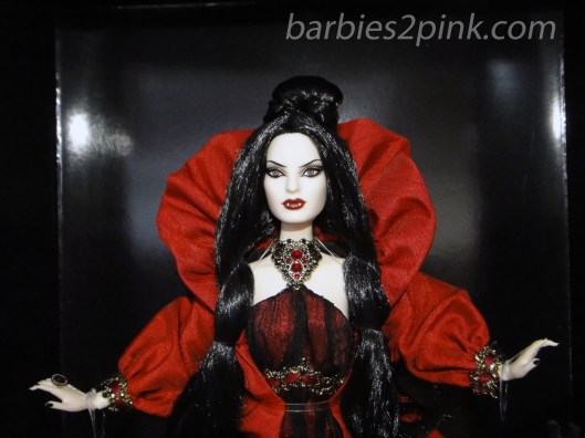 Um colar de "ouro" antigo com pedras vermelhas e casaco vermelho | Foto: Caori